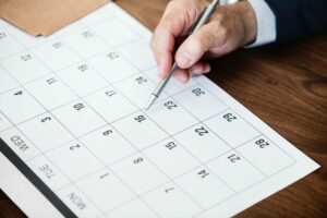 person about to write in a printed calendar