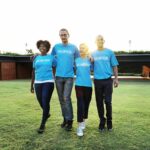 Alumni volunteer engagement: Image of four alumni volunteers in blue "volunteer" shirts