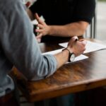 Workplace Bullying in Higher Education - Image of two colleagues arguing at a table