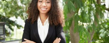 Cheerful businesswoman with hands crossed