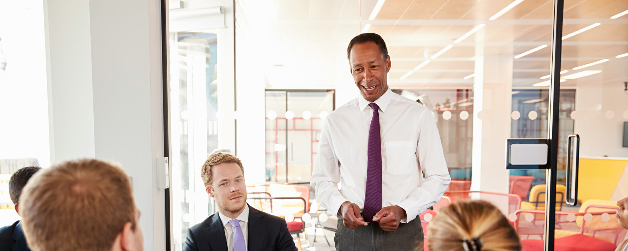 Black male manager addressing employees in a meeting