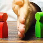 Hand dividing two wooden block figures