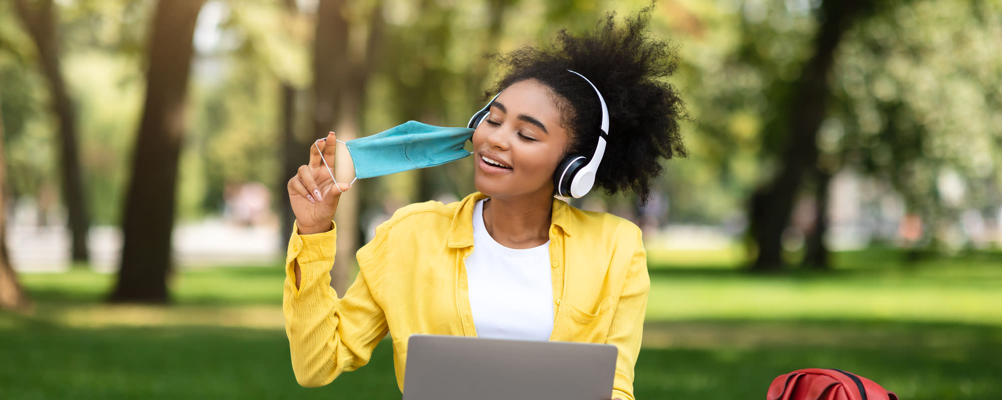 College student taking off a mask