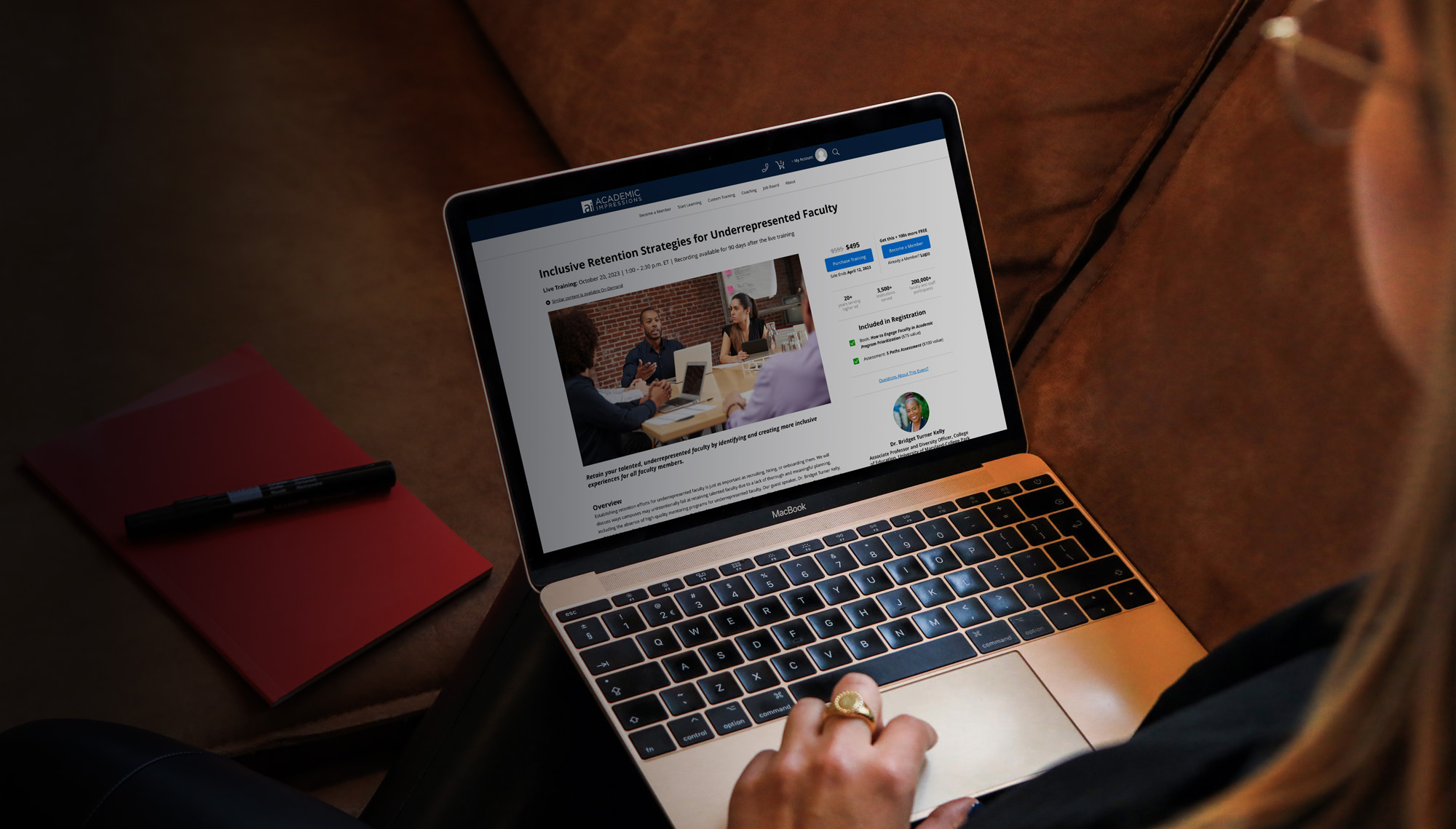 Professional on laptop looking at an Academic Impressions event