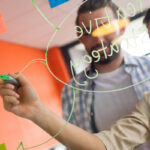 Two professionals discussing over sticky notes