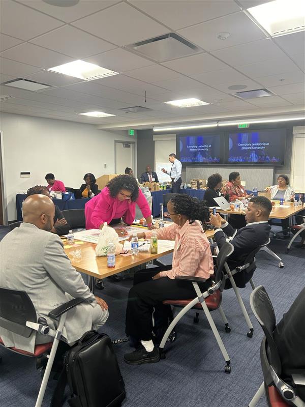 On campus workshop led by Academic Impressions showing higher ed professionals working together on an activity.