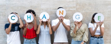 Group of people holding letter signs that spell change.